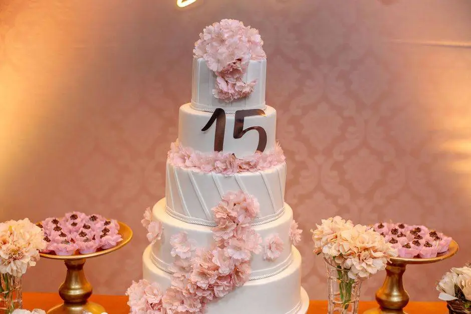 Luxurious multi-layer cake adorned with pink floral decor for a 15th birthday celebration.