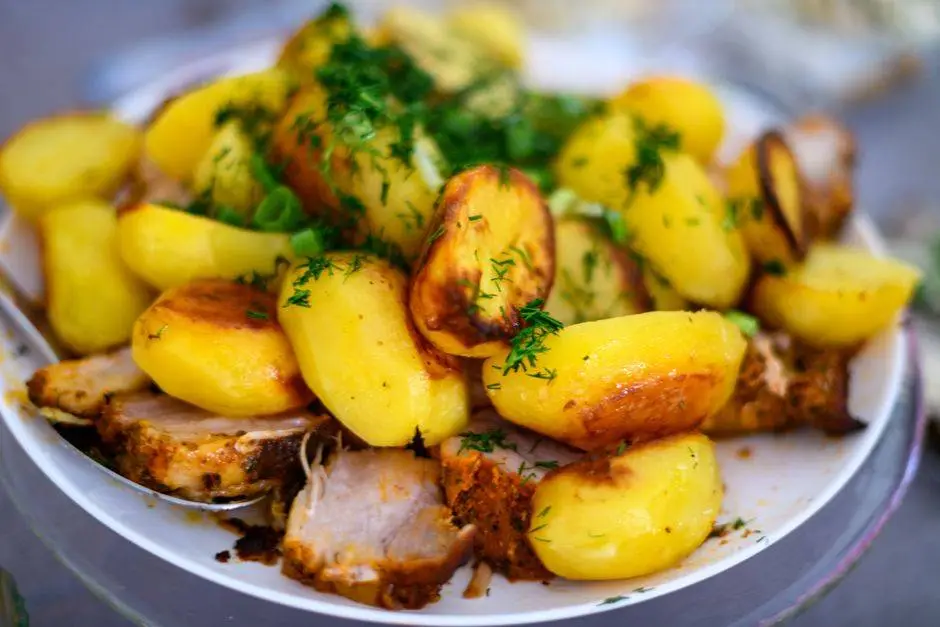 Delicious roasted potatoes and meat garnished with fresh dill, perfect for a hearty meal.