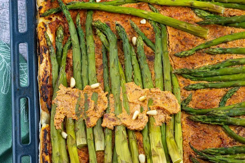 Tasty asparagus tart topped with savory pine nuts on a golden crust.